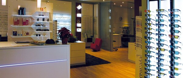 Modernes Optikergeschäft mit großer Auswahl an Brillen und Sonnenbrillen im Ausstellungsraum.